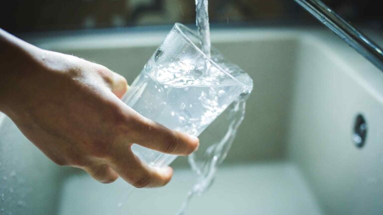 person getting clean drinking water from faucet in their home