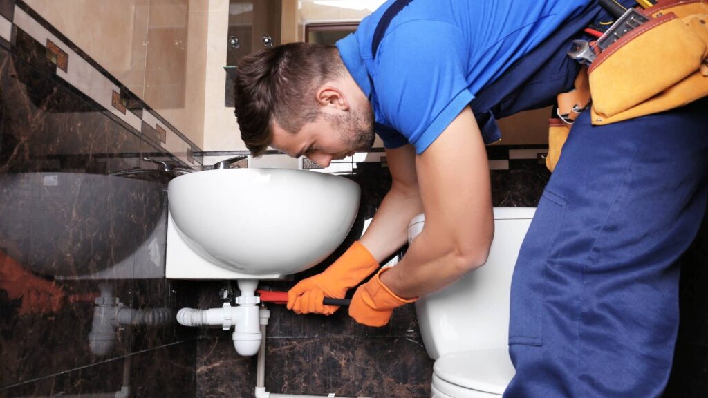 plumber fixing a bathroom sink