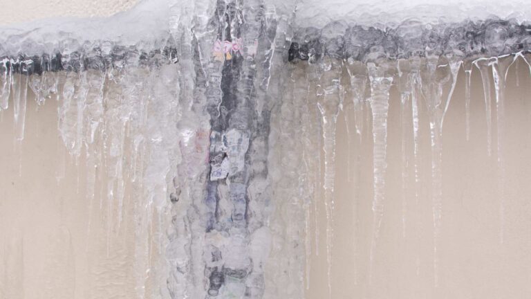 frozen pipes on the side of a building