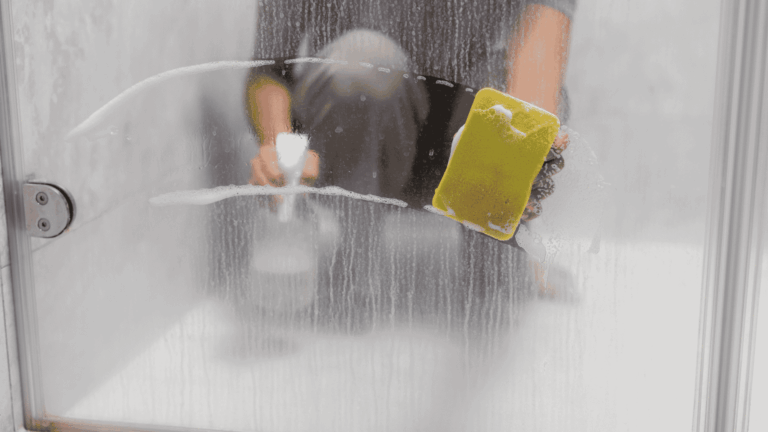 Person Cleaning Hard Water in Shower