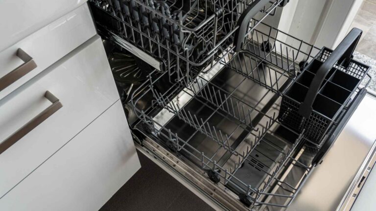 open dishwasher that is empty and clean next to white drawer cabinets in kitchen